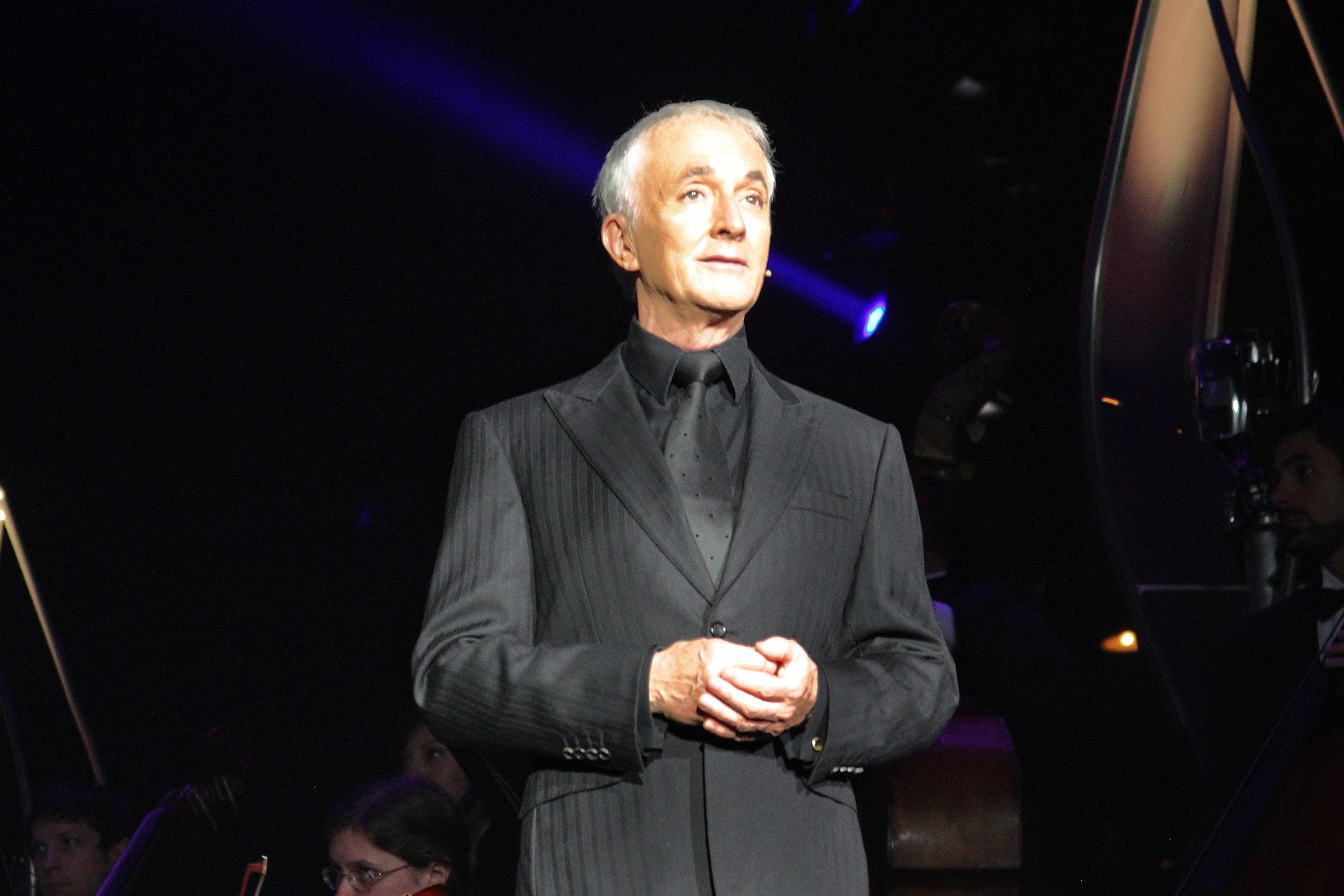 Anthony Daniels on stage in a dark suit at Star Wars In Concert