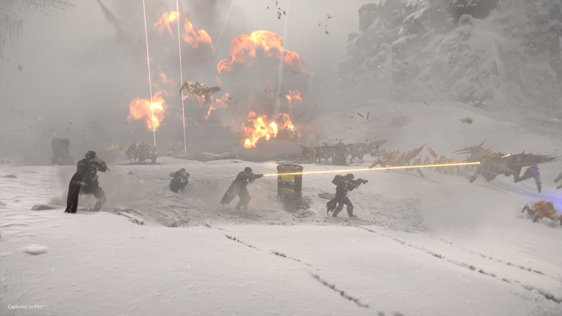 Helldivers fight through explosions on a snowy planet in Helldivers 2